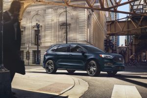 Blue 2022 Ford Edge turning a corner on a street.