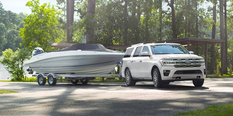 A white 2024 Ford Expedition pulling a boat.